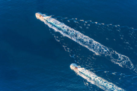 Yacht at the sea. Aerial view of luxury floating ship at sunset. Colorful landscape with boat in marina bay, blue sea. Top view from drone of yacht. Luxury cruise. Seascape with motorboat. Ocean